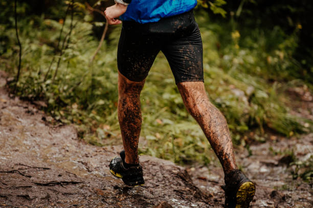 istock back man runner in mud running on autumn trail in forest 1030927098