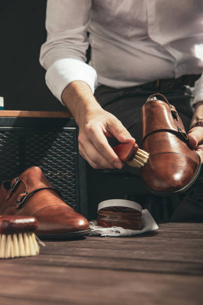 istock Man applies shoe polish with a small brush 1030929718