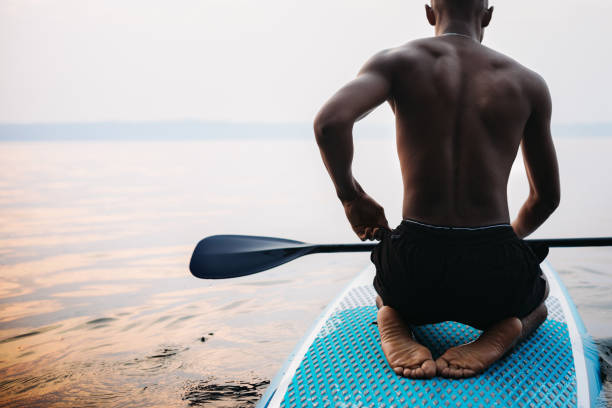 fotografii de stoc, fotografii și imagini scutite de redevențe cu young adult man paddleboarding puget sunet în timpul verii - paddleboard