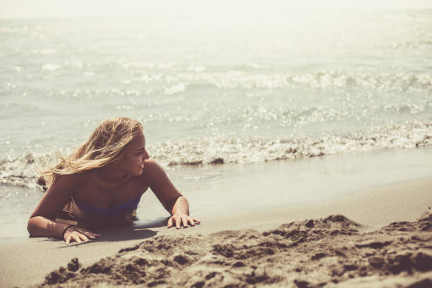 istock Young woman sunbathing on coast 1030931380
