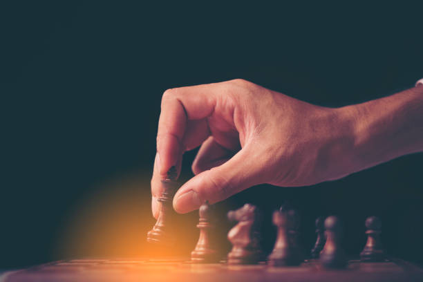 istock Retro style image of a businessman with clasped hands planning strategy with chess figures on an old wooden table. 1030932078