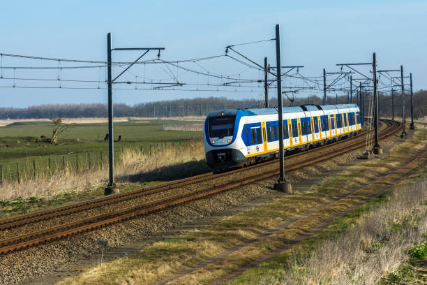 Dutch electric train in the countryside Flevoland, the Netherlands - March 26, 2016: Dutch sprinter train traveling through countryside. tasrail stock pictures, royalty-free photos & images