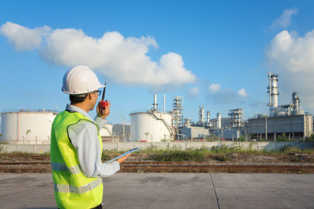 istock Engineer working in a oil refinery with talking on the walkie-talkie for controlling work 1030940526