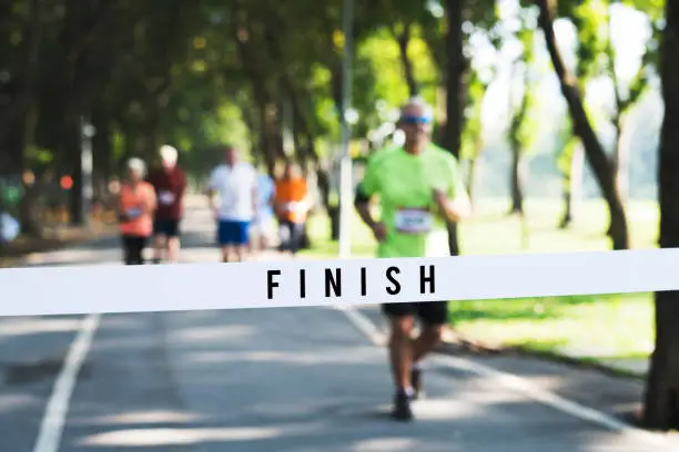 Mature man running towards the finish line