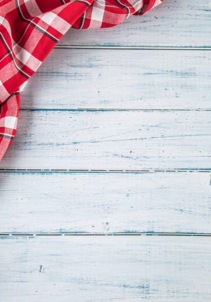Top of view red checkered tablecloth on wooden table.