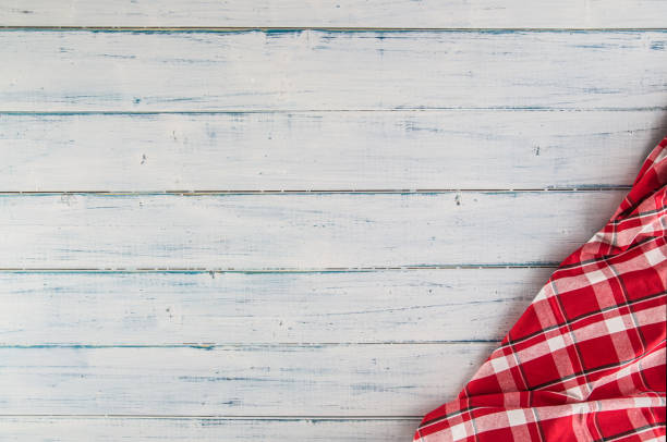 istock Top of view red checkered tablecloth on wooden table. 1030949340