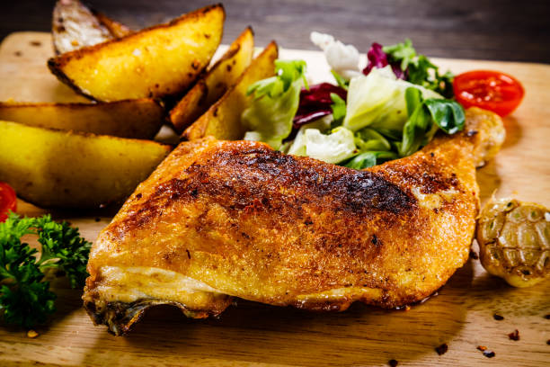 istock Roast chicken leg with fried potatoes and fresh vegetables 1030951910