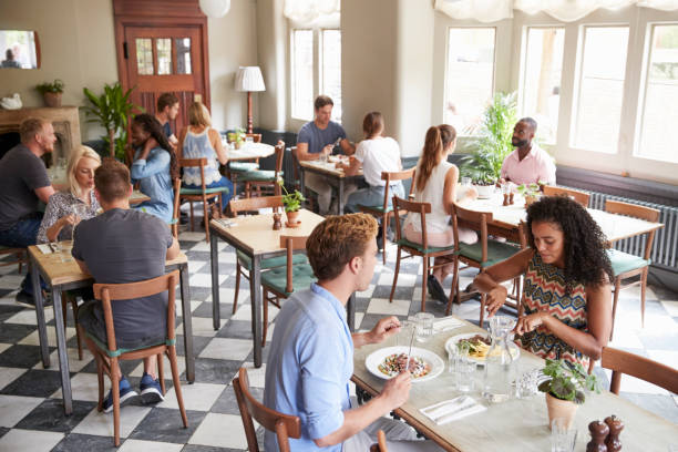 istock Customers Enjoying Meals In Busy Restaurant 1030953198