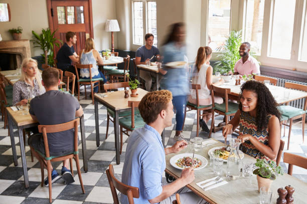 istock Customers Enjoying Meals In Busy Restaurant 1030953200