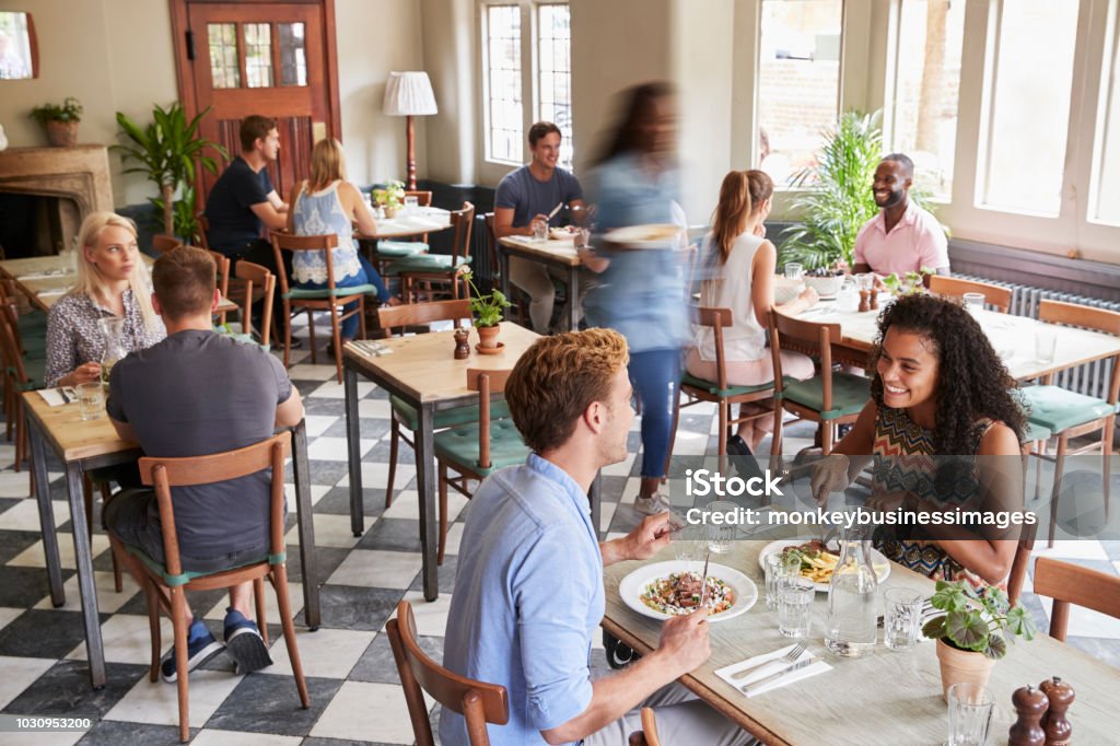Clientes desfrutar de refeições no restaurante movimentado - Foto de stock de Restaurante royalty-free