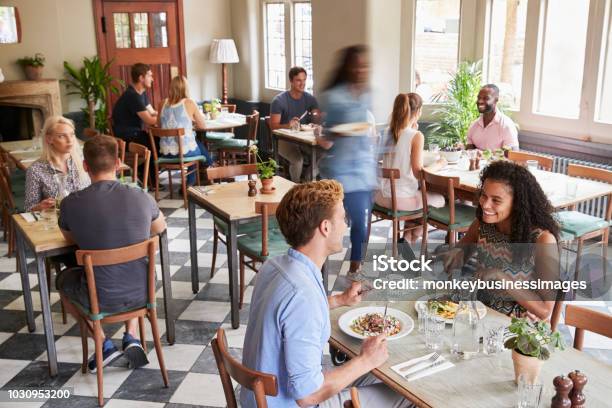 Foto de Clientes Desfrutar De Refeições No Restaurante Movimentado e mais fotos de stock de Restaurante