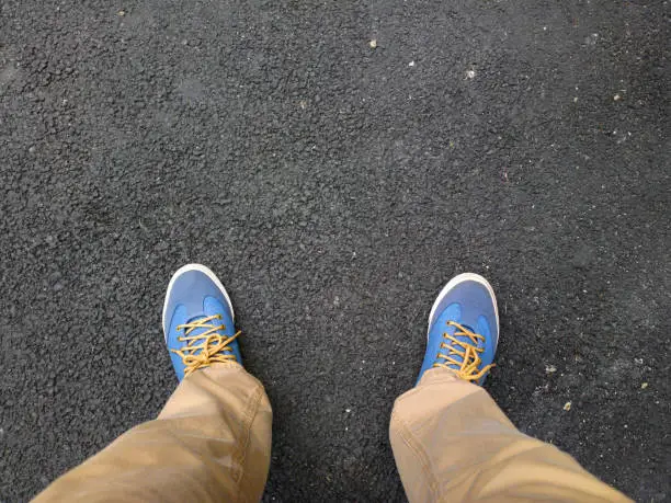 Photo of Feet on the asphalt.