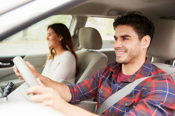 istock Mixed race couple driving on vacation, side view 1030958076