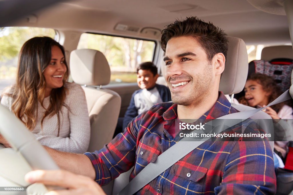 Mãe se vira para seus filhos no banco de trás do carro - Foto de stock de Carro royalty-free