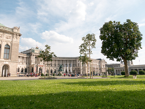 Vienna, Austria - July 20 2018: Hofburg palace and square view, people walking in Vienna, Austria.The Austrian National Library is the largest library in Austria, with more than 12 million items in its various collections. The library is located in the Neue Burg Wing of the Hofburg in center of Vienna.