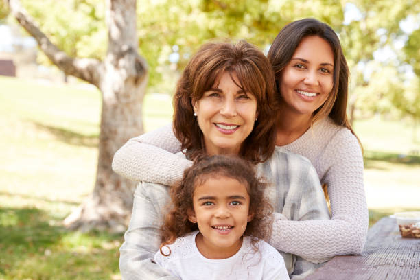 tre generazioni di donne a un picnic in famiglia in un parco - nipote femmina foto e immagini stock