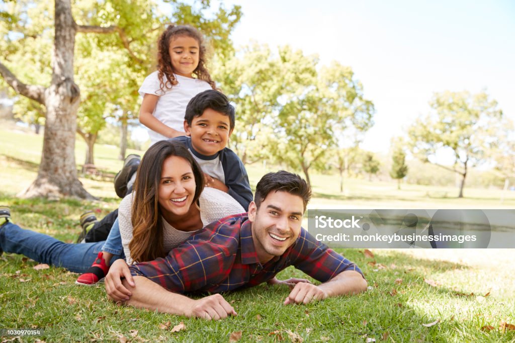 Kleine Kinder und Eltern in Haufen auf dem Rasen liegen Porträt - Lizenzfrei Lateinamerikanische Abstammung Stock-Foto