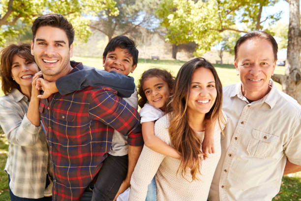 three generation multi ethnic family portrait in a park - multi ethnic group family child standing imagens e fotografias de stock