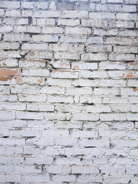 istock Old brick wall with white paint background texture close up 1030981478