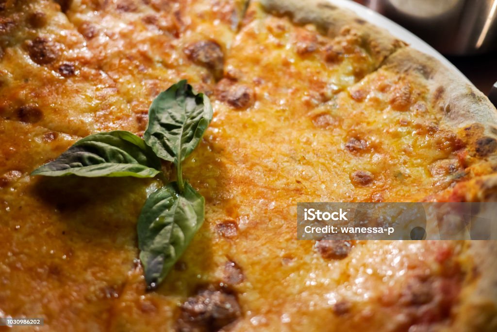 Delicious, cheesy and freshly baked Pizza Margherita, the archetype of Neapolitan pizza and the Italian unification. Decorated with Basil. Simple but perfect. Delicious, cheesy and freshly baked Pizza Margherita, the archetype of Neapolitan pizza and the Italian unification. Decorated with Basil. Selective focus. Close Up. Baked Stock Photo
