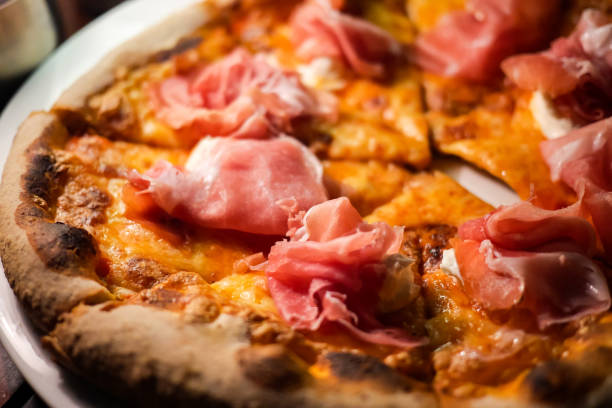 イタリアのプロシュット ・ ディ ・ パルマ ピザやトマト、モッツァレラチーズ、生ハムとパルメザン チーズのピッツァのおいしい、安っぽいと焼きたてのパン。 - pizza homemade margharita pizza parma ham ストックフォトと画像
