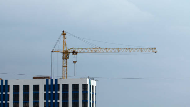istock Construction cranes and high-rise building under construction against blue sky. 1030989838