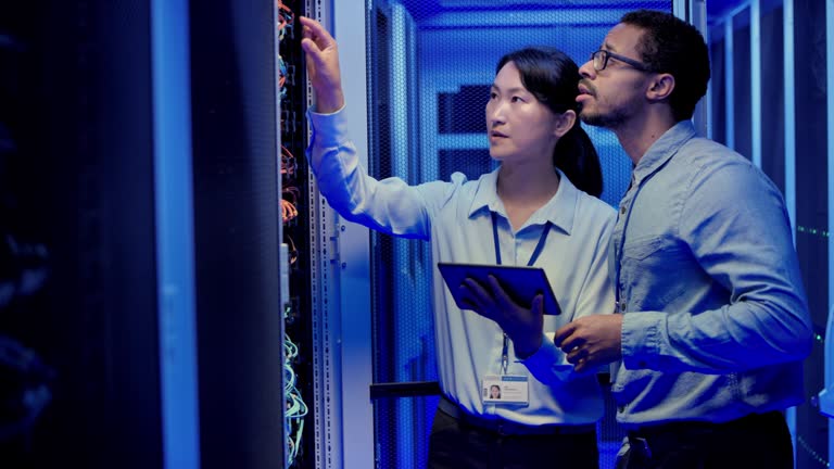 DS Asian IT engineer and her male coworker checking the server because of a reported problem