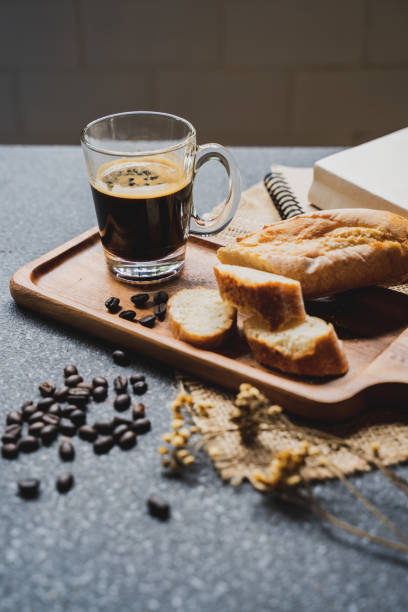 istock A coffee, bread, wood plate and book setting on black background 1031001660