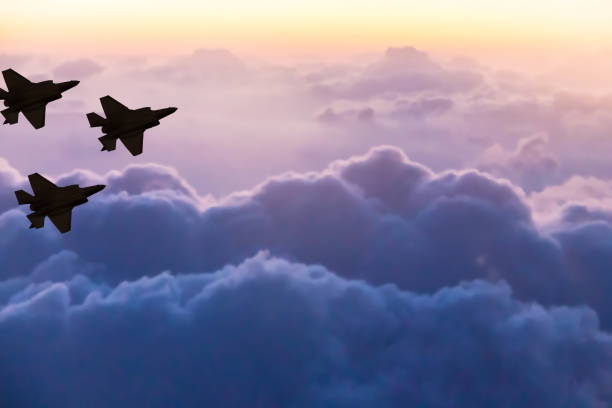 Silhouettes of three F-35 aircraft on sunset sky background stock photo