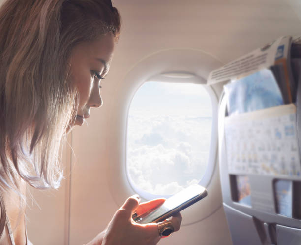 istock Woman is using mobile phone in airplane 1031010892