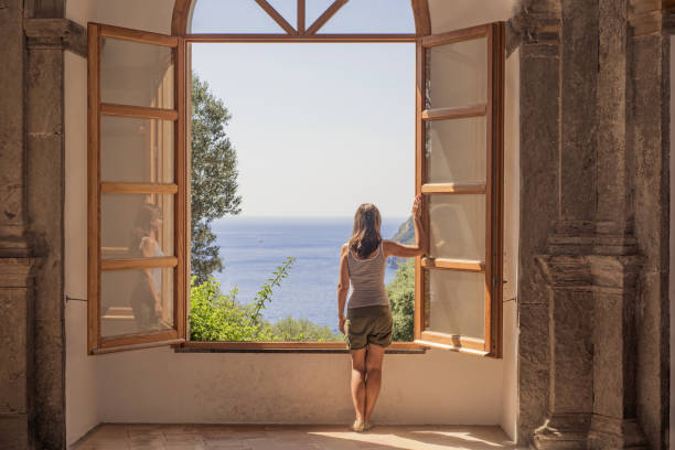 istock Young woman at a large open window. 1031032928
