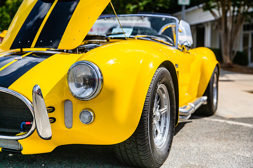 Matthews, North Carolina - September 3, 2018: Front view of a bright yellow Shelby Cobra parked on display with open hood at the Matthews Auto Reunion.