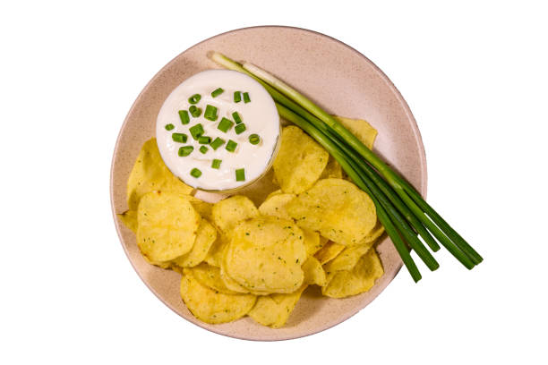 istock Ceramic plate with potato chips and glass bowl with sour cream isolated on a white background 1031038940