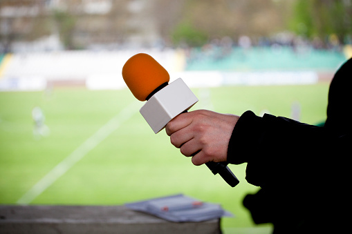 hand hold microphone for  interview during a football match