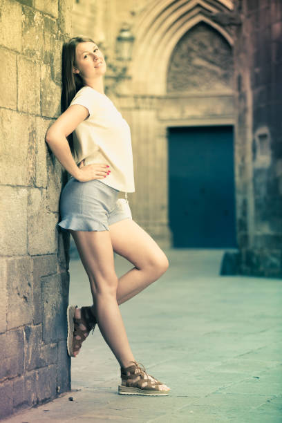 istock Young woman standing near old stone wall 1031058646