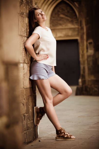 istock Young woman standing near old stone wall 1031058652