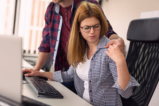 Businessman sexualy harassing female colleague during working hours at a workplace