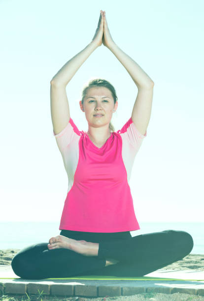 istock Woman training yoga poses on beach 1031058864