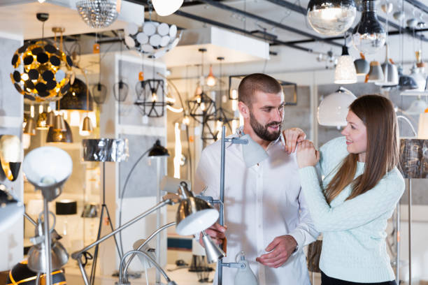 istock Smiling couple customers choosing floor lamp in store 1031060098