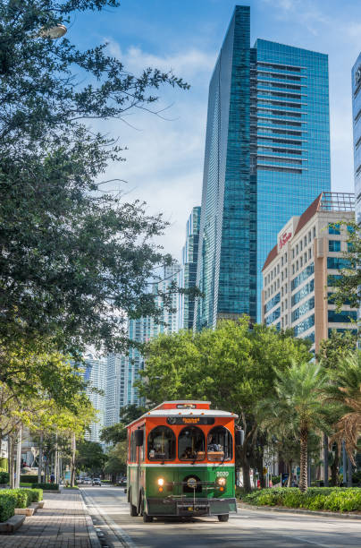 Past and present Miami, Florida, USA - September 3, 2018: Busy and crowded Brickell Avenue at growing Miami downtown district with trolley service, a free public transportation. Streetcar style trolley-replica buses have been implemented in over a dozen cities in Miami-Dade. trolley bus stock pictures, royalty-free photos & images