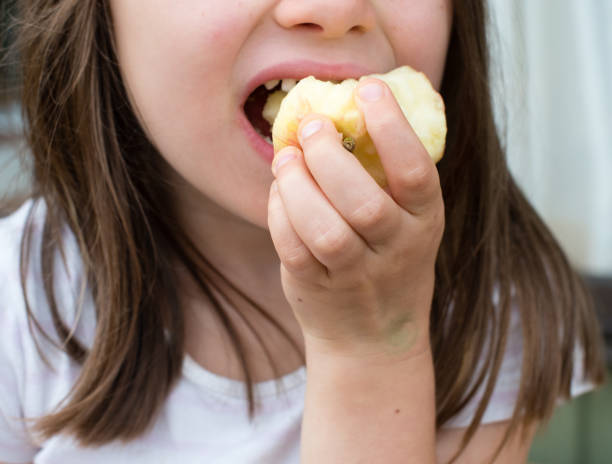 istock Midsection Of Girl Biting Apple 1031060868