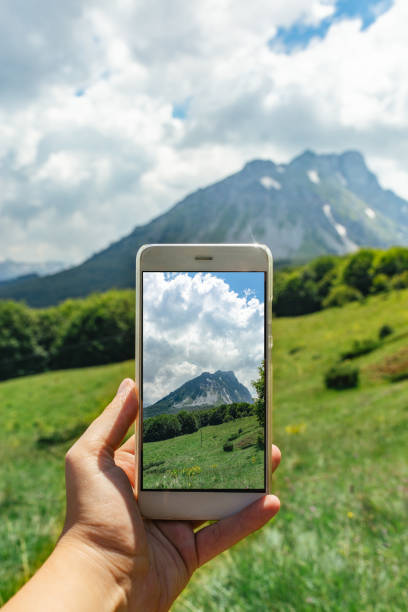 istock Hand taking photo of scenic mountain view 1031061386