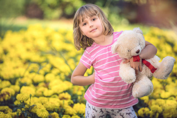 istock Adorable little girl with a white teddy bear 1031082700