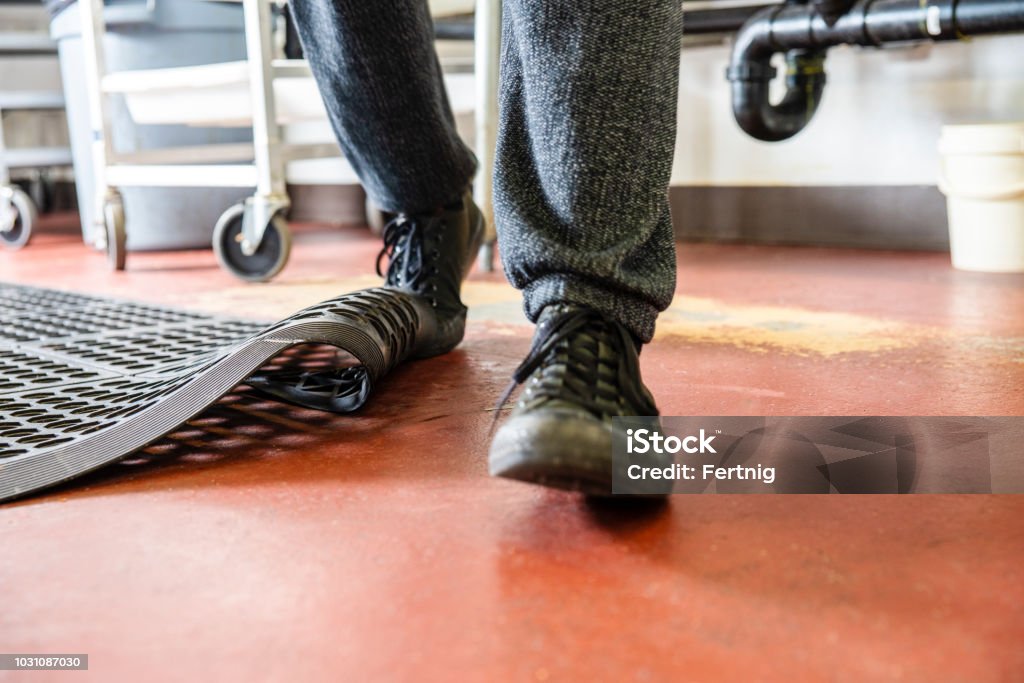 Un hombre dispara en una cocina comercial. - Foto de stock de Tropezar - Caer libre de derechos