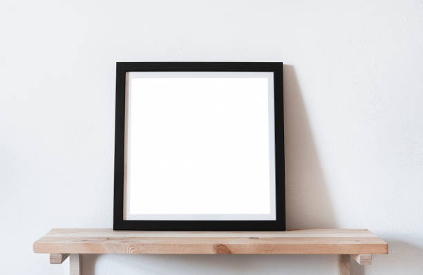 istock Posters square format in black frame in white stylish modern interior on shelf, living room. Design template mockup. 1031094148