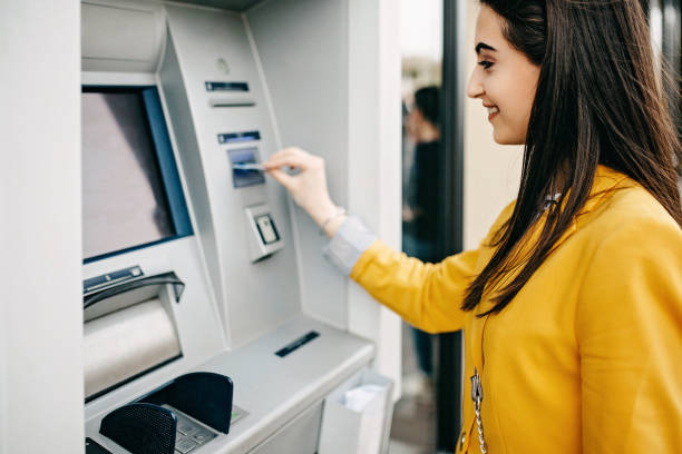 Woman using ATM machine Woman using ATM machine atm photos stock pictures, royalty-free photos & images