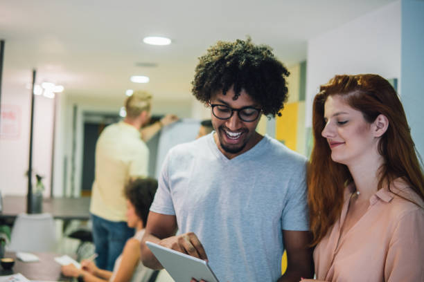istock Smiling young coworkers looking at digital tablet 1031106484