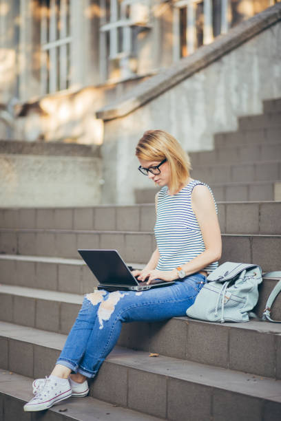istock Student girl studying with laptop on a staircase 1031109050