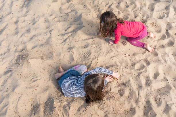 little girls playing in sand pit from above - sandbox child human hand sand imagens e fotografias de stock