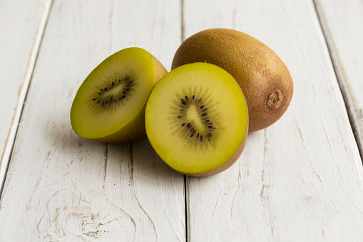 Golden kiwis are a species in which the color of the pulp of the fruit is yellow and not green like in the common kiwi. The kiwi is a tropical fruit, rich in antioxidants, vitamin C, high in fiber and low in calories, so its consumption is very healthy and convenient in weight loss diets. Photography made with natural day light. Horizontal orientation.